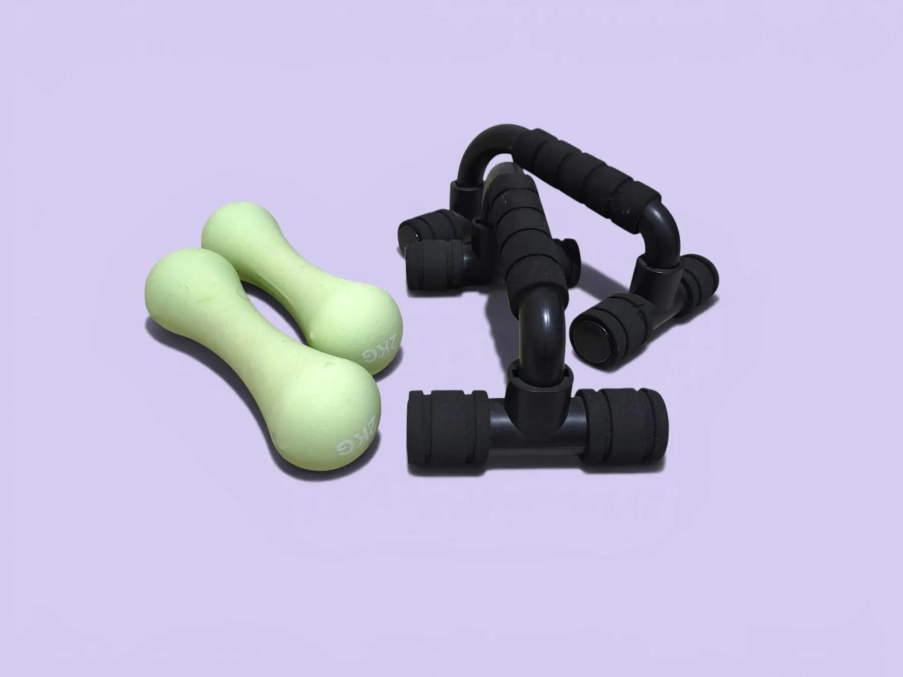 Two light green dumbbells on a lilac background